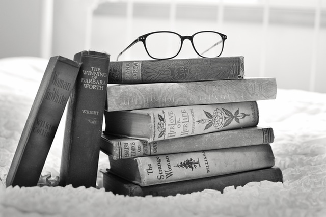 A pile of books & a pair of spectacles on top