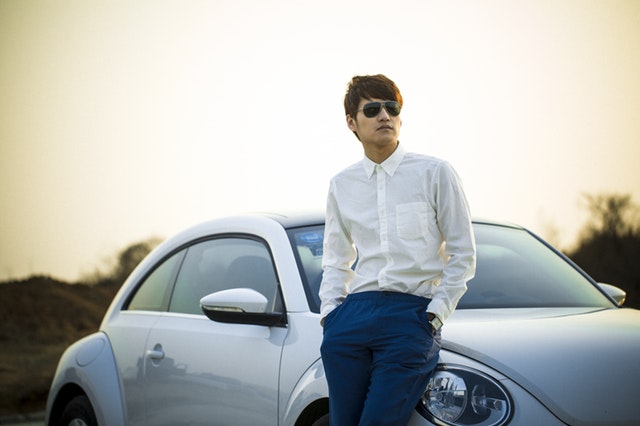 Young man posing with nice car
