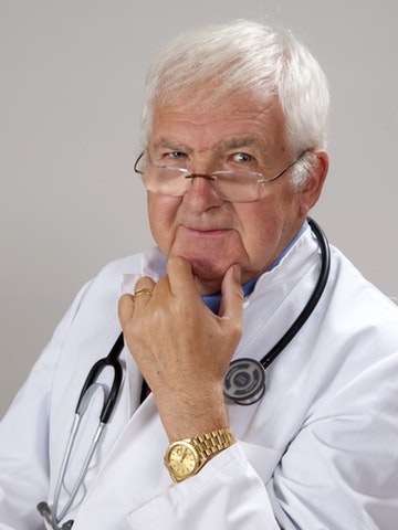 Doctor with coat, stethoscope and gold watch