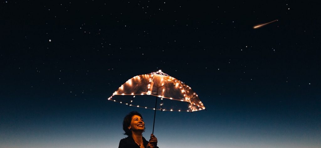 Lady with umbrella underneath shooting star