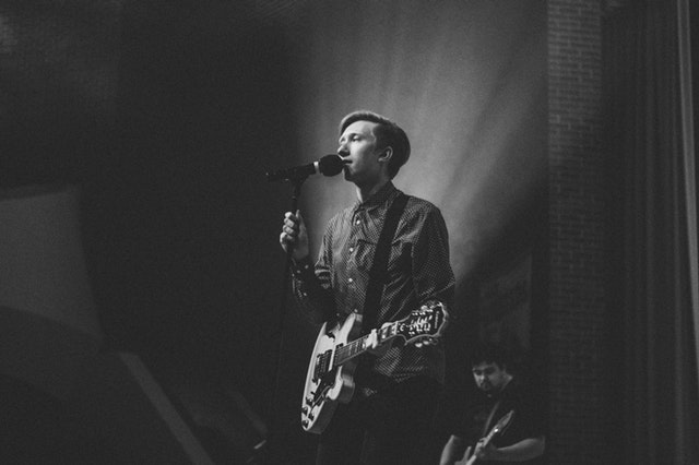 Singer holding guitar on stage