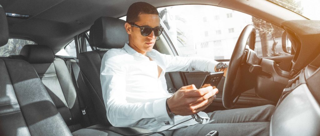 Rich guy in car looking at phone
