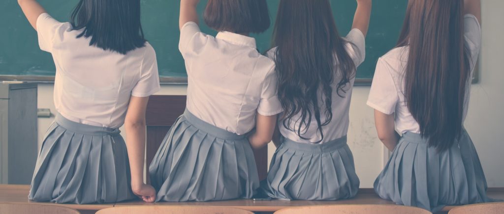 4 schoolgirls sitting in front of blackboard