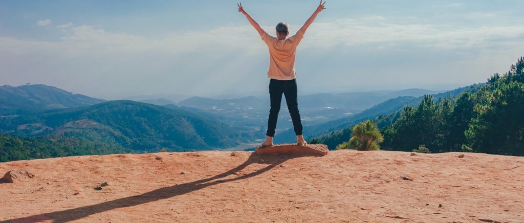 Woman celebrating at top of mountain