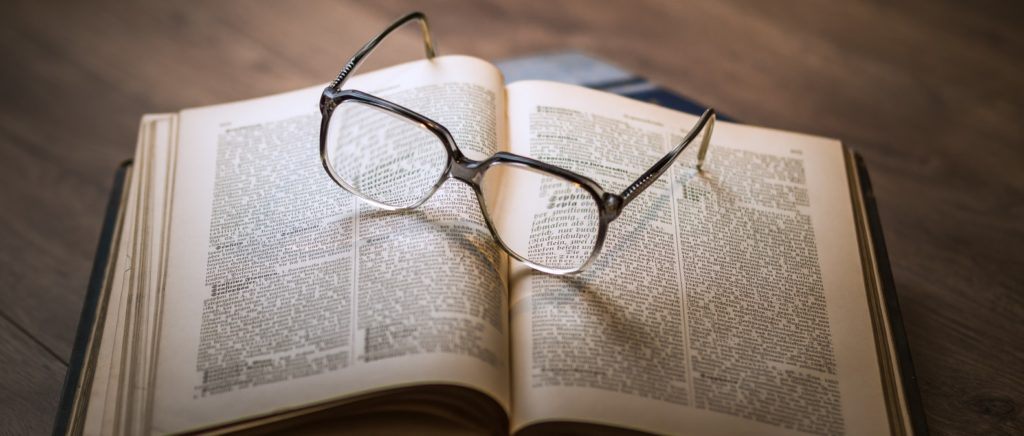 Pair of glasses on an open old book