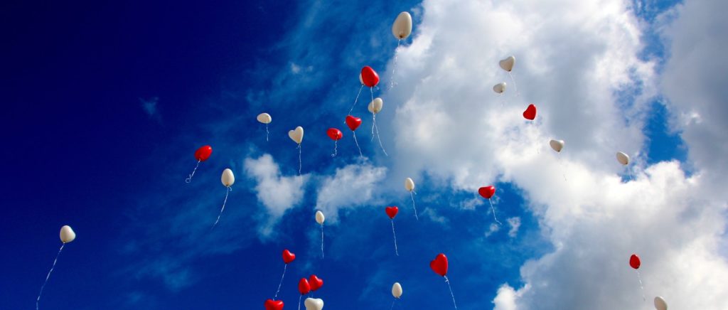 Many love-themed balloons flying into sky