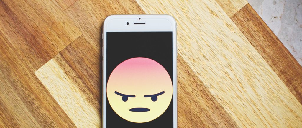 Angry emoji on iPhone on table