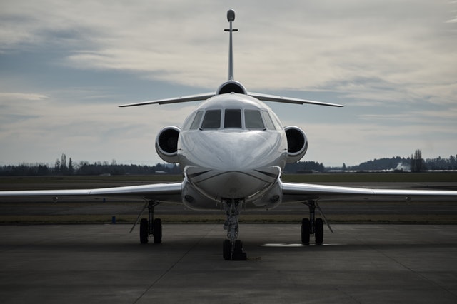 Private jet on runway, illustrating the money concept of frugality