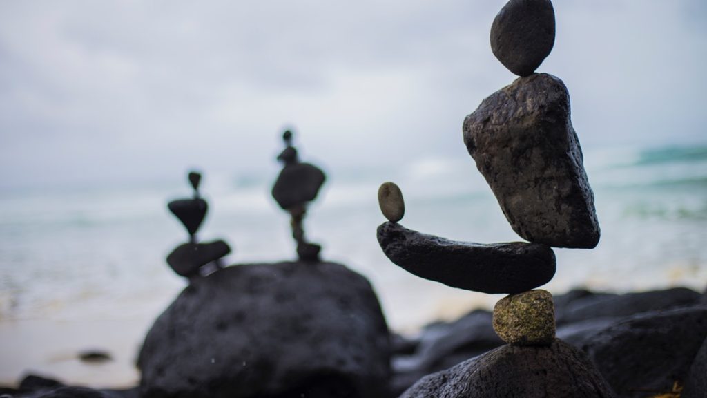 Stones stacked beside the sea, signifying balance