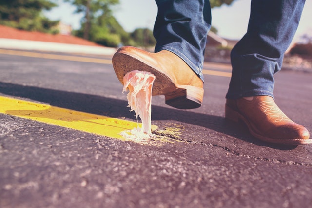 Guy stepping on chewing gum; linked to money principle 4: protect the downside